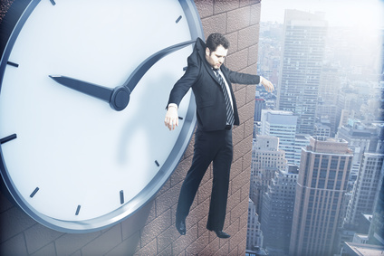 Time management concept with businessman hanging on clock arrow above city. 3D Rendering
